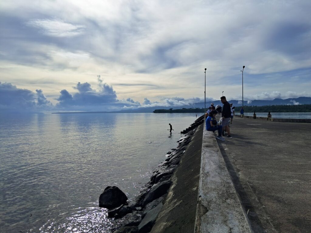 tourists enjoying the view and cool sea breeze of Albay Gulf